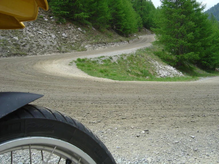 Kurvige Schotterstraße aus Sicht des Motorrads Kurvige Schotterstraße aus Sicht des Motorrads