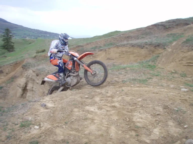 Enduro-Fahrer auf KTM an einer staubigen Steigung