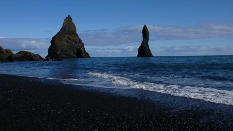 Felsnadeln Reynisdrangar vor dem schwarzen Strand bei Vík